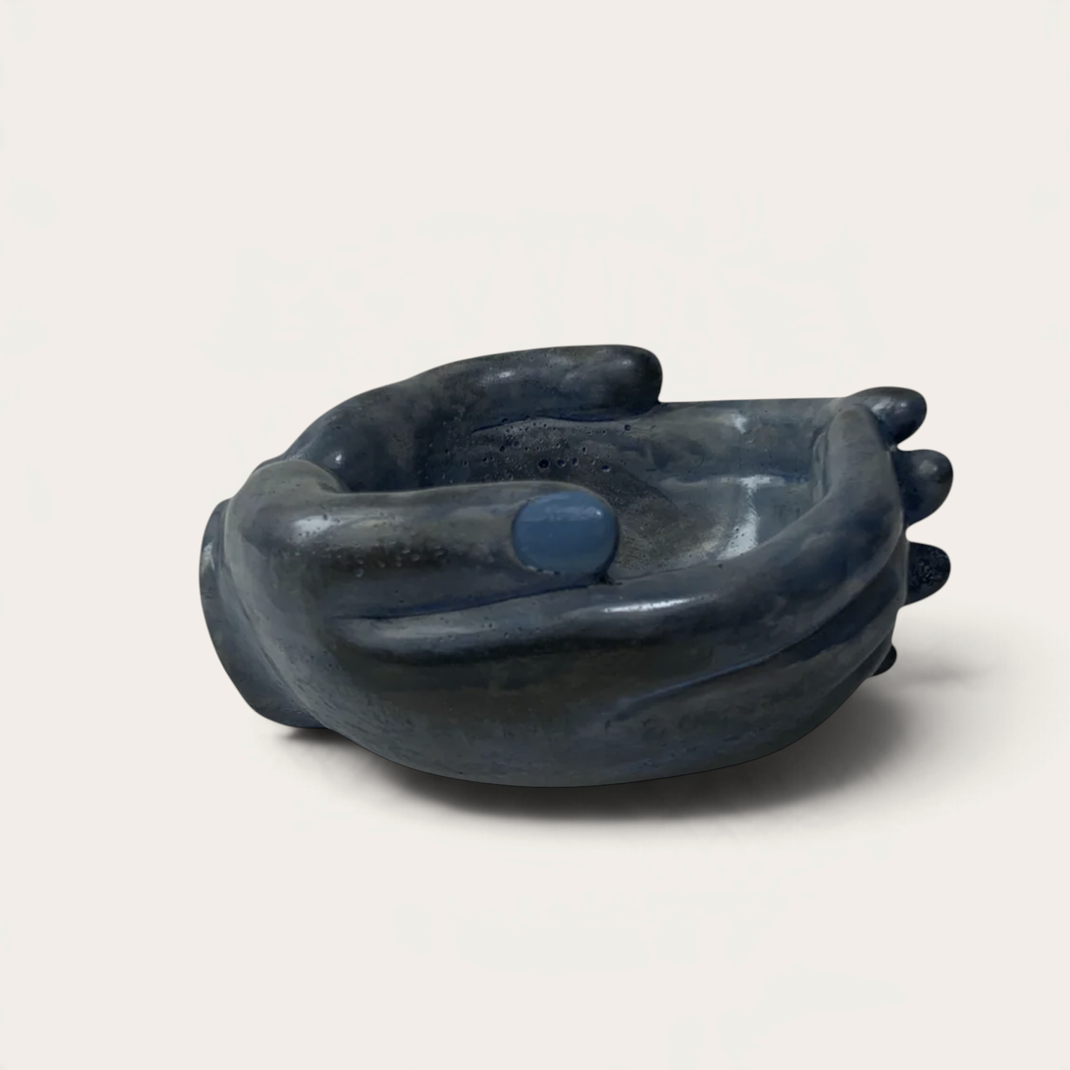 Escultura artesanal Blue Rain de THE IBIZA CANDLES con forma de manos ahuecadas en cerámica azul oscuro brillante.