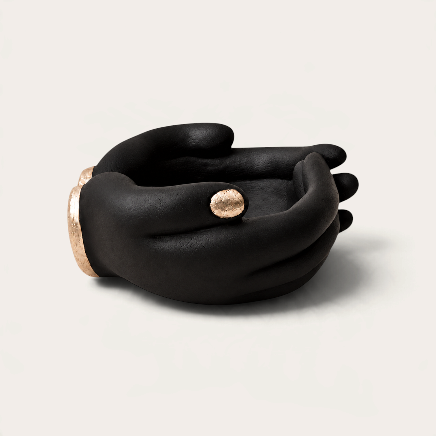 Vela escultórica Black Tuxedo de THE IBIZA CANDLES con forma de manos negras y detalles en pan de oro