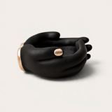 Vela escultórica Black Tuxedo de THE IBIZA CANDLES con forma de manos negras y detalles en pan de oro