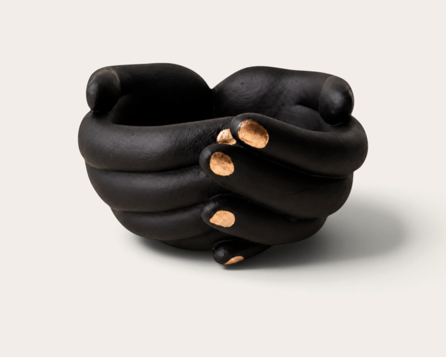 Vela escultórica Black Tuxedo de THE IBIZA CANDLES con forma de manos entrelazadas en negro mate y detalles dorados.