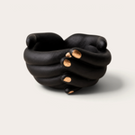 Vela escultórica Black Tuxedo de THE IBIZA CANDLES con forma de manos entrelazadas en negro mate y detalles dorados.