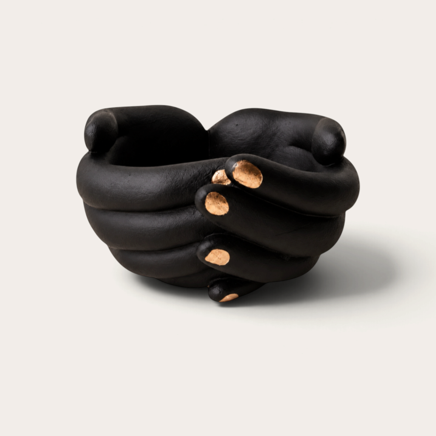 Vela escultórica Black Tuxedo de THE IBIZA CANDLES con forma de manos entrelazadas en negro mate y detalles dorados.