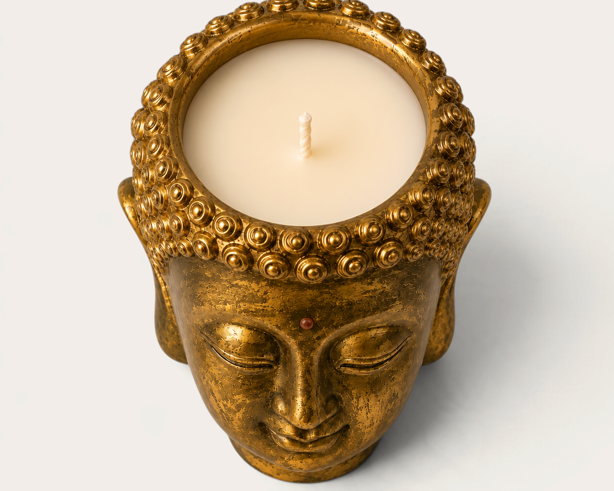 Vela artesanal THE IBIZA CANDLES con forma de cabeza de Buda en color bronce dorado, pieza decorativa escultórica.