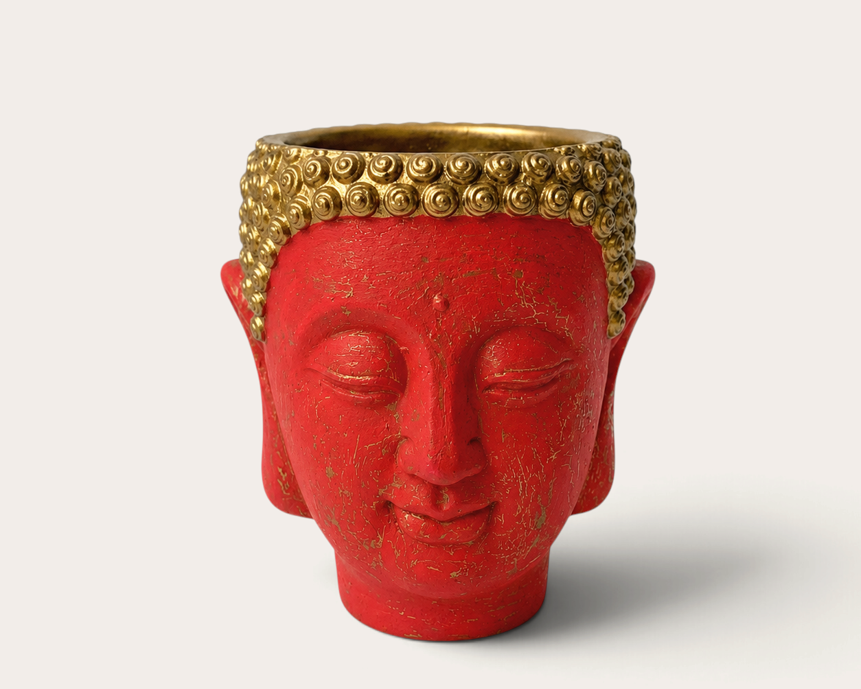 Vela escultórica THE IBIZA CANDLES con forma de cabeza de Buda roja y detalles dorados pintada a mano