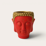 Vela escultórica THE IBIZA CANDLES con forma de cabeza de Buda roja y detalles dorados pintada a mano