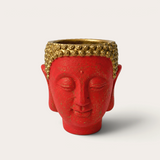 Vela escultórica THE IBIZA CANDLES con forma de cabeza de Buda roja y detalles dorados pintada a mano