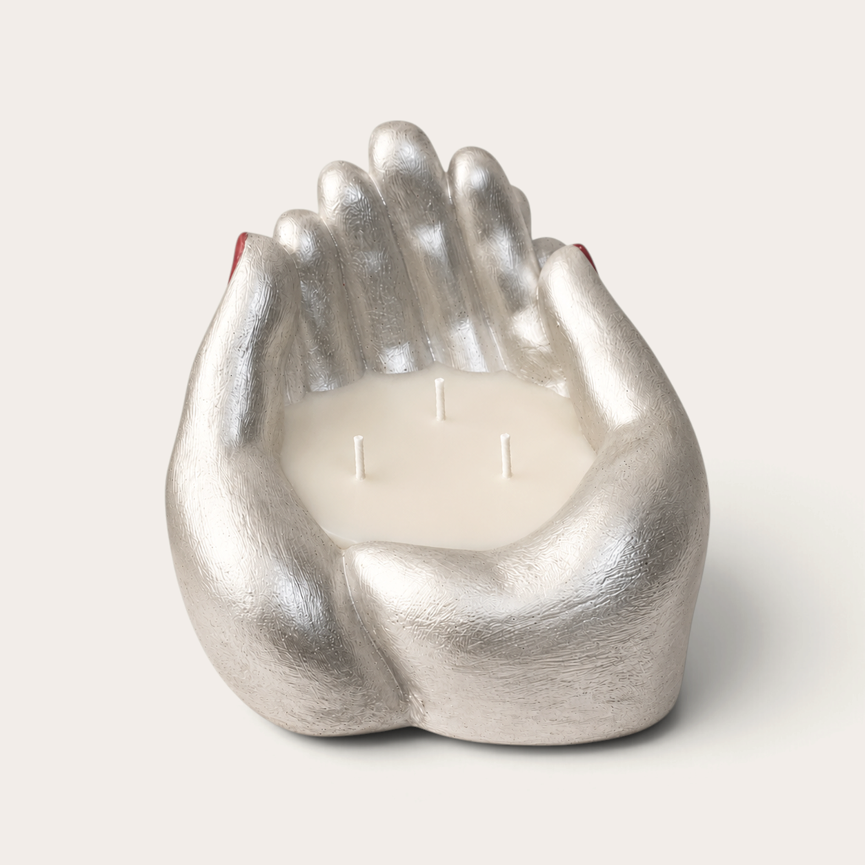 Vela artesanal Pearl de THE IBIZA CANDLES con forma de manos plateadas pintadas a mano y tres mechas