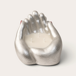 Vela artesanal Pearl de THE IBIZA CANDLES con forma de manos plateadas pintadas a mano y tres mechas