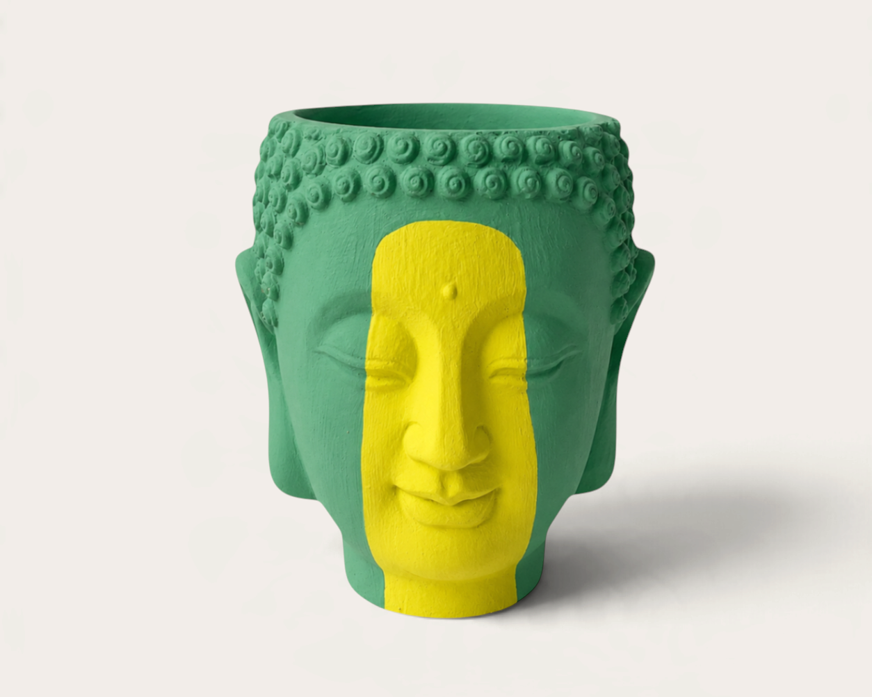Vela escultórica THE IBIZA CANDLES modelo Brazilian con forma de cabeza de Buda pintada a mano en verde y amarillo.