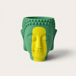 Vela escultórica THE IBIZA CANDLES modelo Brazilian con forma de cabeza de Buda pintada a mano en verde y amarillo.