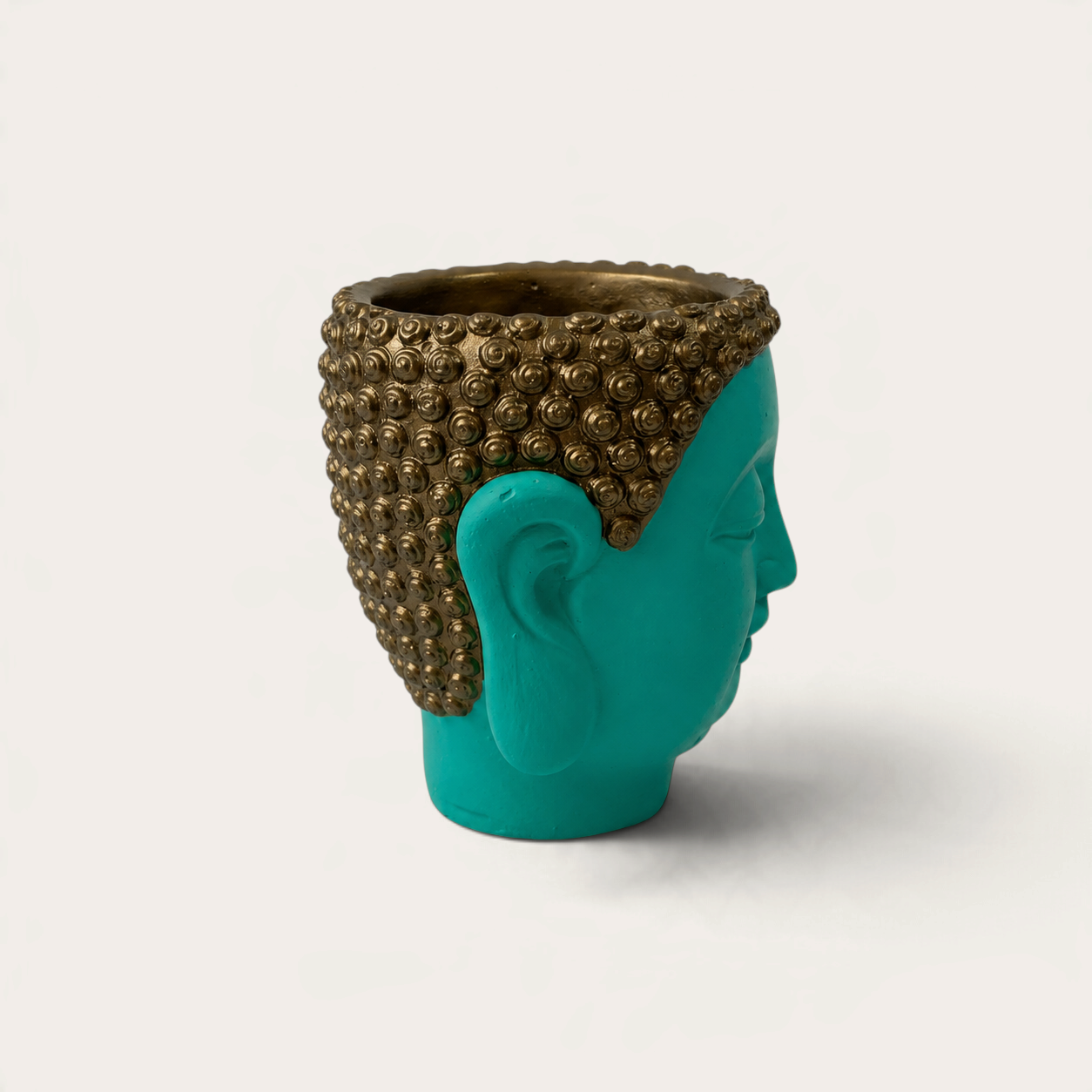 Vela artesanal THE IBIZA CANDLES con forma de cabeza de Buda en color turquesa y detalles dorados en el cabello