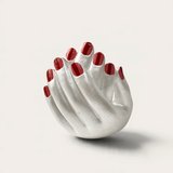 Vela artesanal Pearl de THE IBIZA CANDLES con forma de manos entrelazadas en color plata y uñas pintadas de rojo.