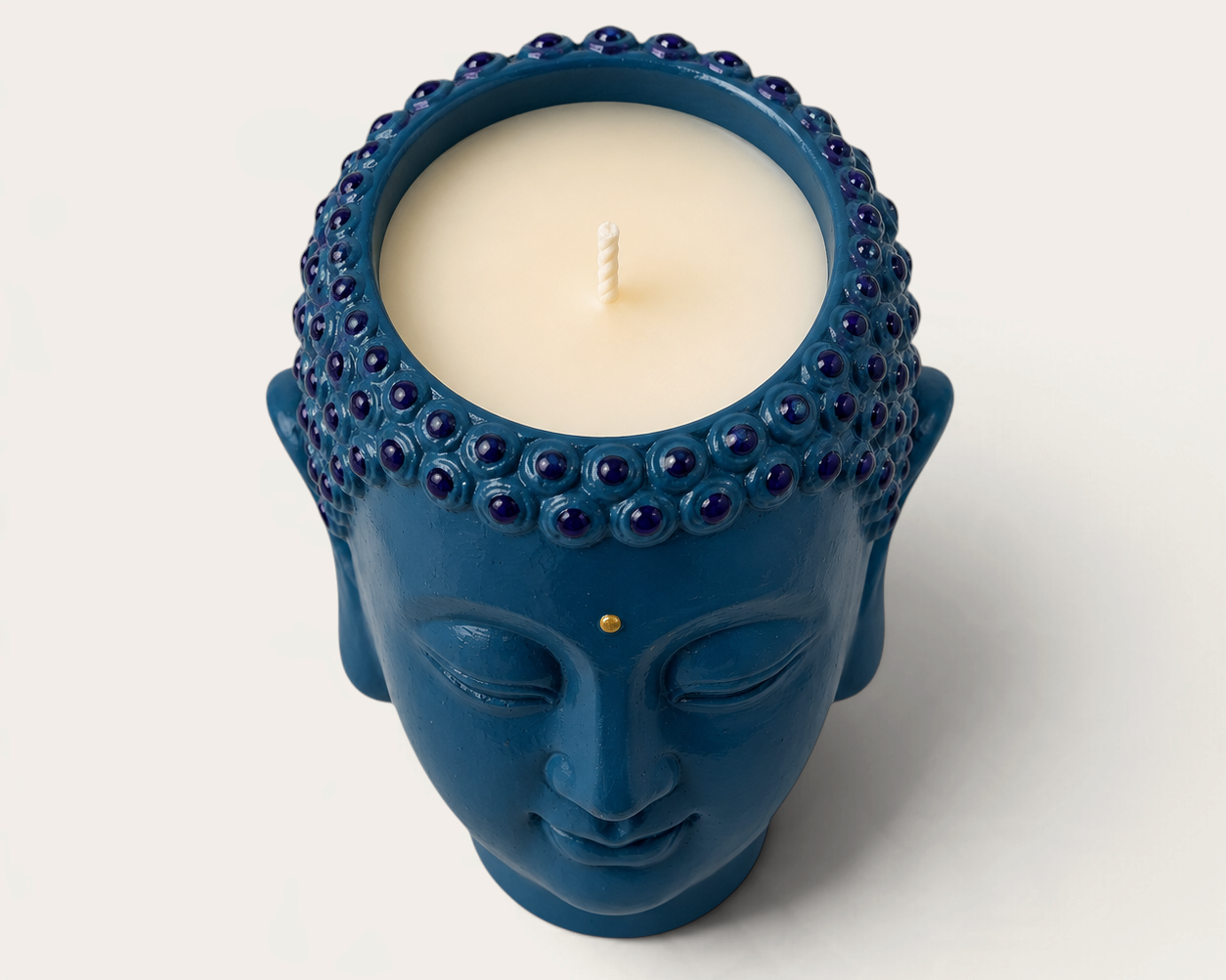 Vela THE IBIZA CANDLES con forma de cabeza de Buda azul pintada a mano, ideal como pieza decorativa reutilizable.
