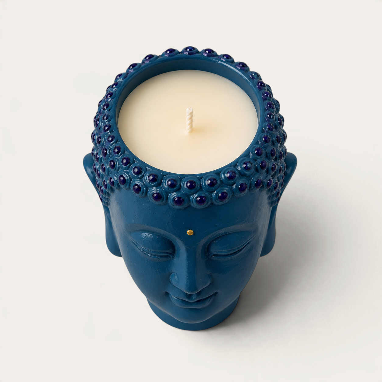 Vela THE IBIZA CANDLES con forma de cabeza de Buda azul pintada a mano, ideal como pieza decorativa reutilizable.