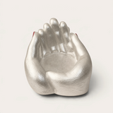 Vela escultórica Pearl de THE IBIZA CANDLES con forma de manos unidas en color plata, pieza artesanal de Fabio Camarotta