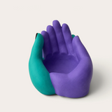 Vela escultórica THE IBIZA CANDLES con forma de manos entrelazadas pintada a mano en tonos morado y turquesa.