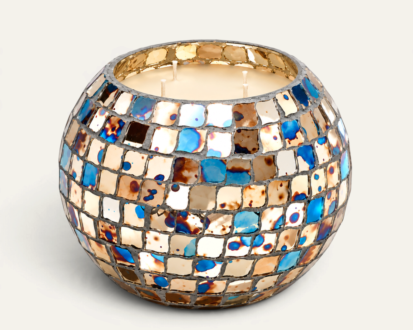 Vela aromática Hippie de THE IBIZA CANDLES en recipiente esférico de mosaico multicolor con tonos azules y dorados.