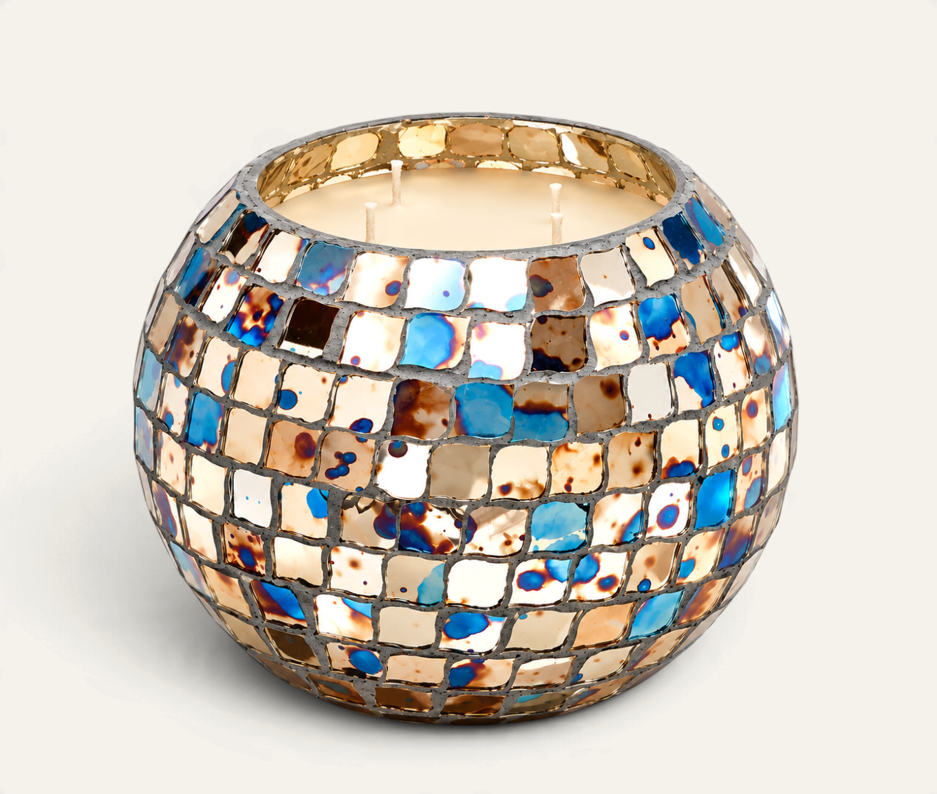 Vela aromática Hippie de THE IBIZA CANDLES en recipiente esférico de mosaico multicolor con tonos azules y dorados.