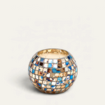 Vela aromática Hippie de THE IBIZA CANDLES en recipiente esférico de mosaico multicolor con tonos azules y dorados.
