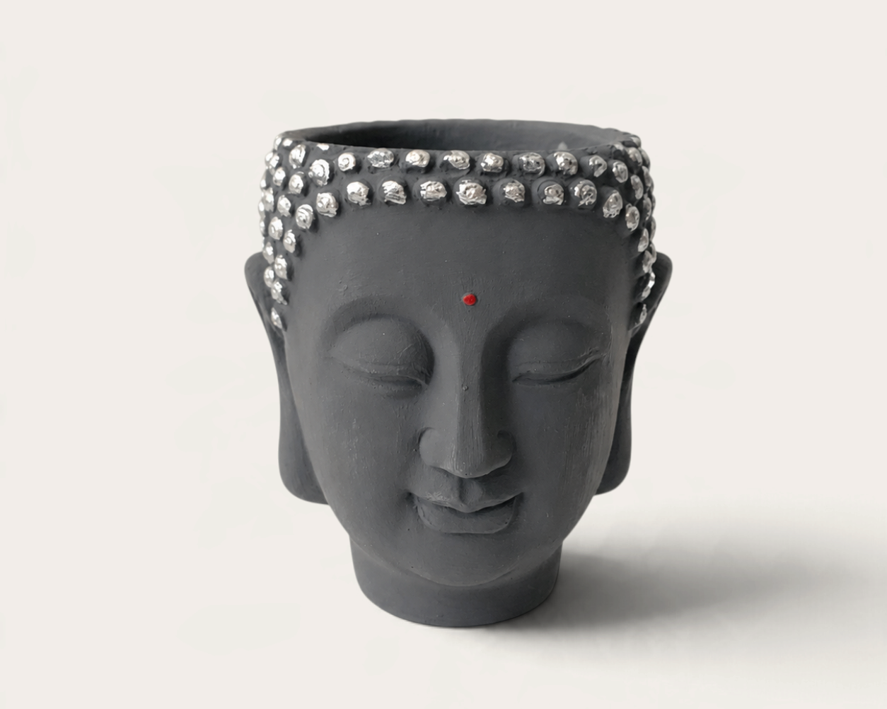 Vela artesanal Dark Moon de THE IBIZA CANDLES con forma de cabeza de Buda gris y detalles plateados