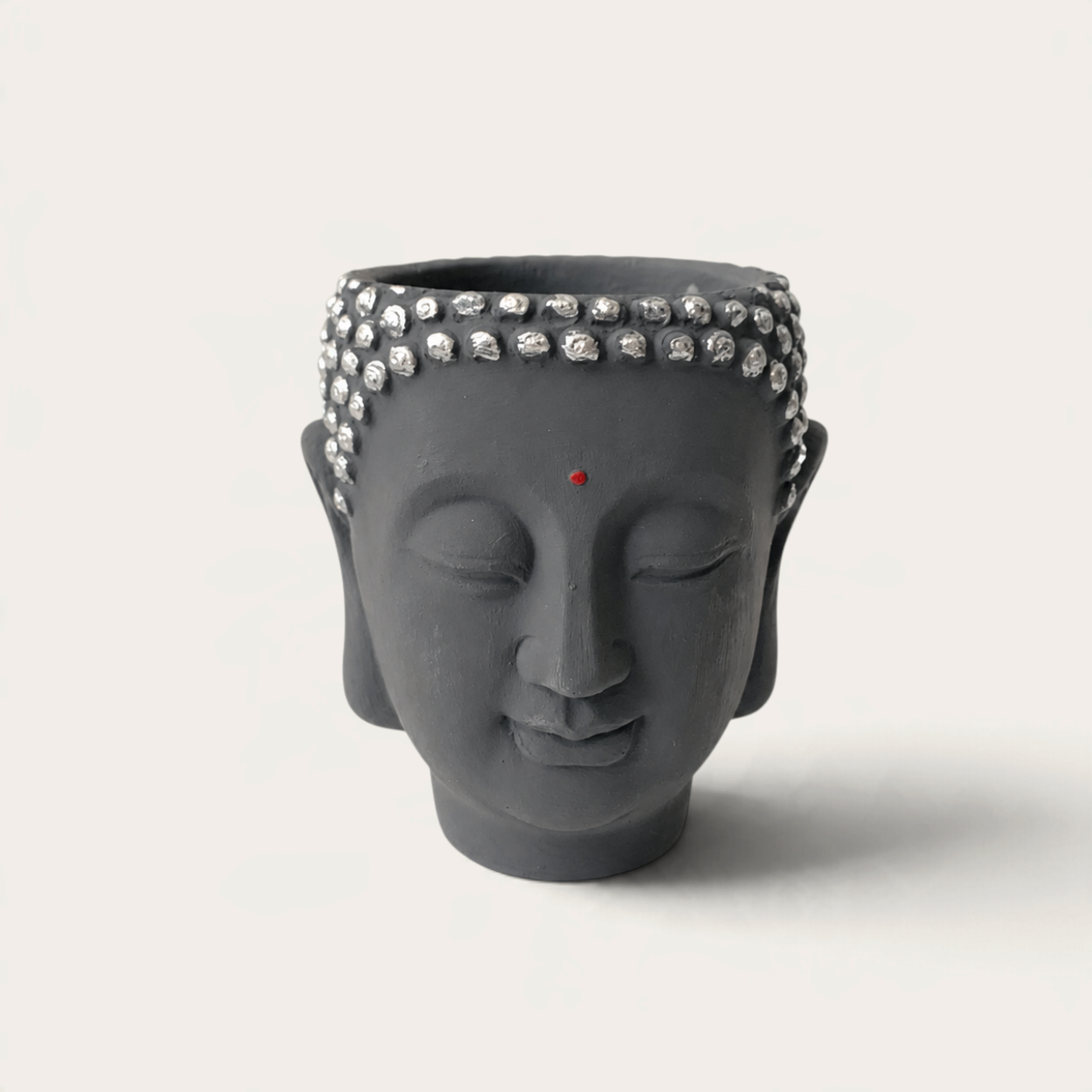 Vela artesanal Dark Moon de THE IBIZA CANDLES con forma de cabeza de Buda gris y detalles plateados