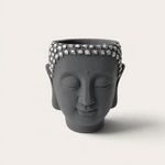 Vela artesanal Dark Moon de THE IBIZA CANDLES con forma de cabeza de Buda gris y detalles plateados