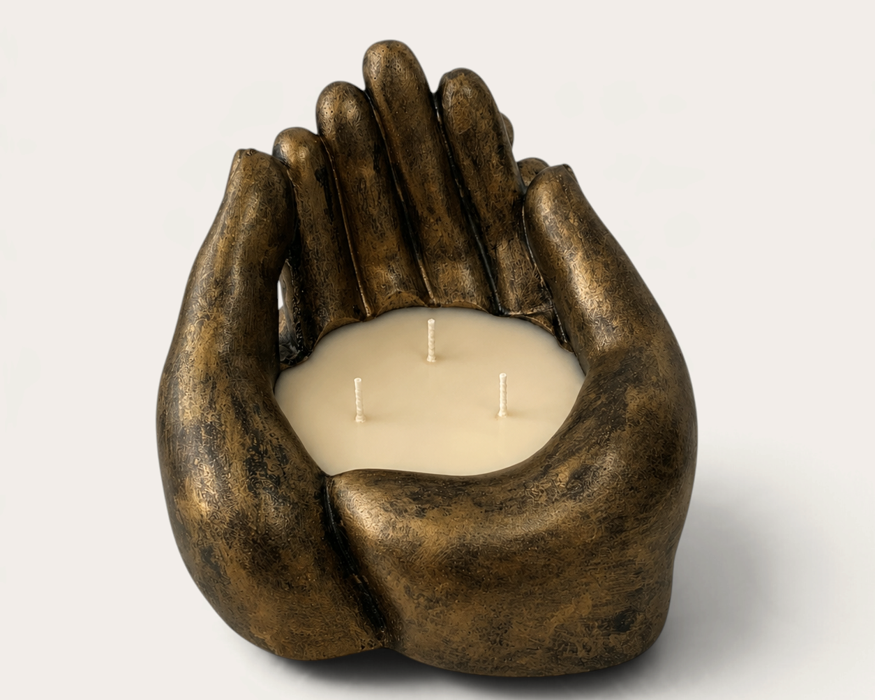 Vela artesanal Dark Bronze de THE IBIZA CANDLES con forma de manos ahuecadas, acabado en bronce oscuro y tres mechas.