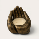 Vela artesanal Dark Bronze de THE IBIZA CANDLES con forma de manos ahuecadas, acabado en bronce oscuro y tres mechas.