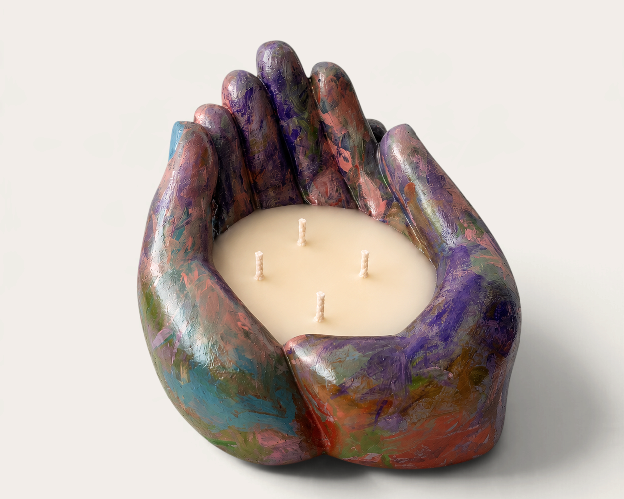 Vela artesanal THE IBIZA CANDLES con forma de manos ahuecadas, pintada a mano en tonos azules y multicolores.