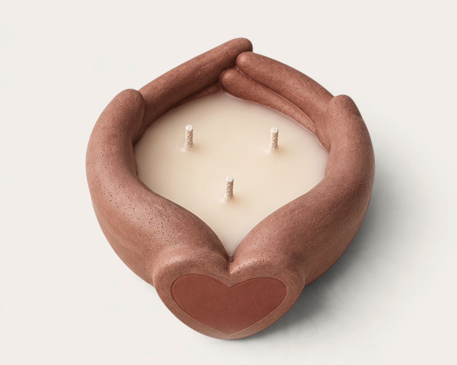 Vela artesanal Red Land de THE IBIZA CANDLES con recipiente de cerámica en forma de manos unidas y corazón