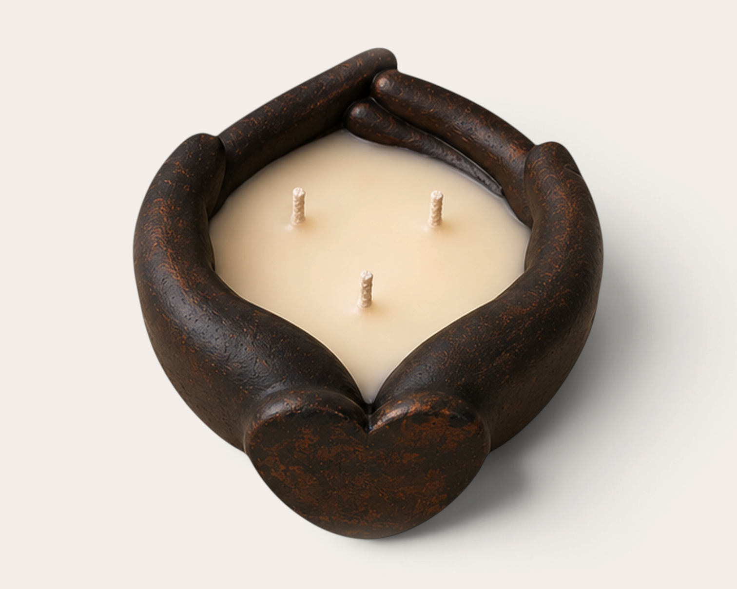 Vela artesanal THE IBIZA CANDLES con forma de manos sosteniendo un corazón, acabado oscuro y tres mechas.
