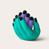 Vela escultórica THE IBIZA CANDLES con forma de manos entrelazadas en turquesa y morado con uñas negras brillantes.