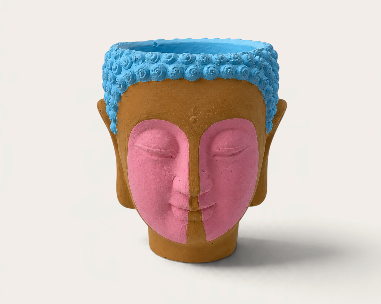 Vela artesanal THE IBIZA CANDLES modelo Indian con forma de cabeza de Buda pintada en tonos azul, rosa y terracota.