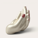 Vela artesanal Pearl de THE IBIZA CANDLES con forma de mano plateada y uñas pintadas de rojo, pieza escultórica.