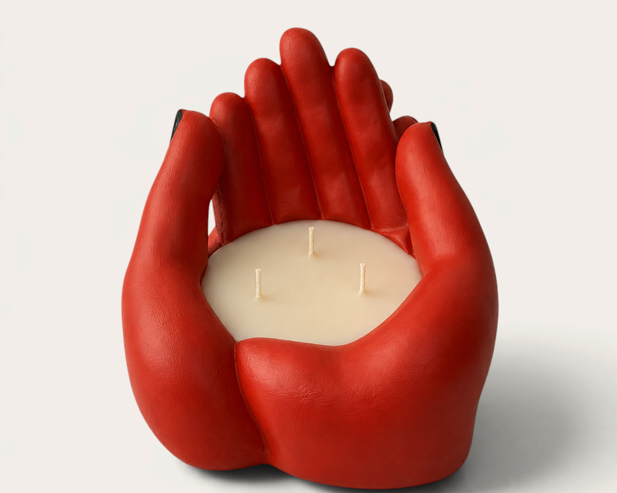 Vela escultórica THE IBIZA CANDLES con forma de manos rojas entrelazadas y tres mechas, diseño artesanal de arte.