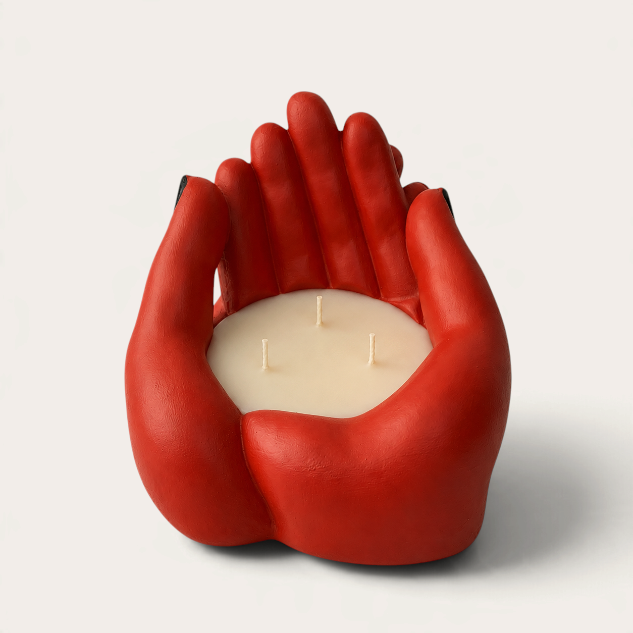 Vela escultórica THE IBIZA CANDLES con forma de manos rojas entrelazadas y tres mechas, diseño artesanal de arte.