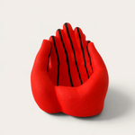 Vela escultórica THE IBIZA CANDLES con forma de manos unidas en color rojo vibrante y rayas negras pintadas a mano