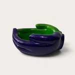 Vela escultórica artesanal THE IBIZA CANDLES con forma de manos entrelazadas en color morado y verde brillante.