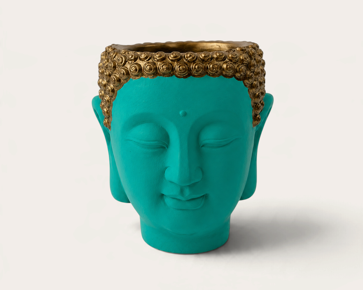 Vela escultórica THE IBIZA CANDLES con forma de cabeza de Buda en color turquesa y detalles dorados pintada a mano.