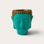 Vela escultórica THE IBIZA CANDLES con forma de cabeza de Buda en color turquesa y detalles dorados pintada a mano.
