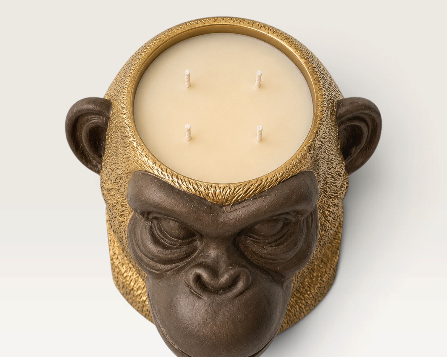 Vela decorativa THE IBIZA CANDLES con forma de cabeza de simio en tonos bronce y oro con cuatro mechas