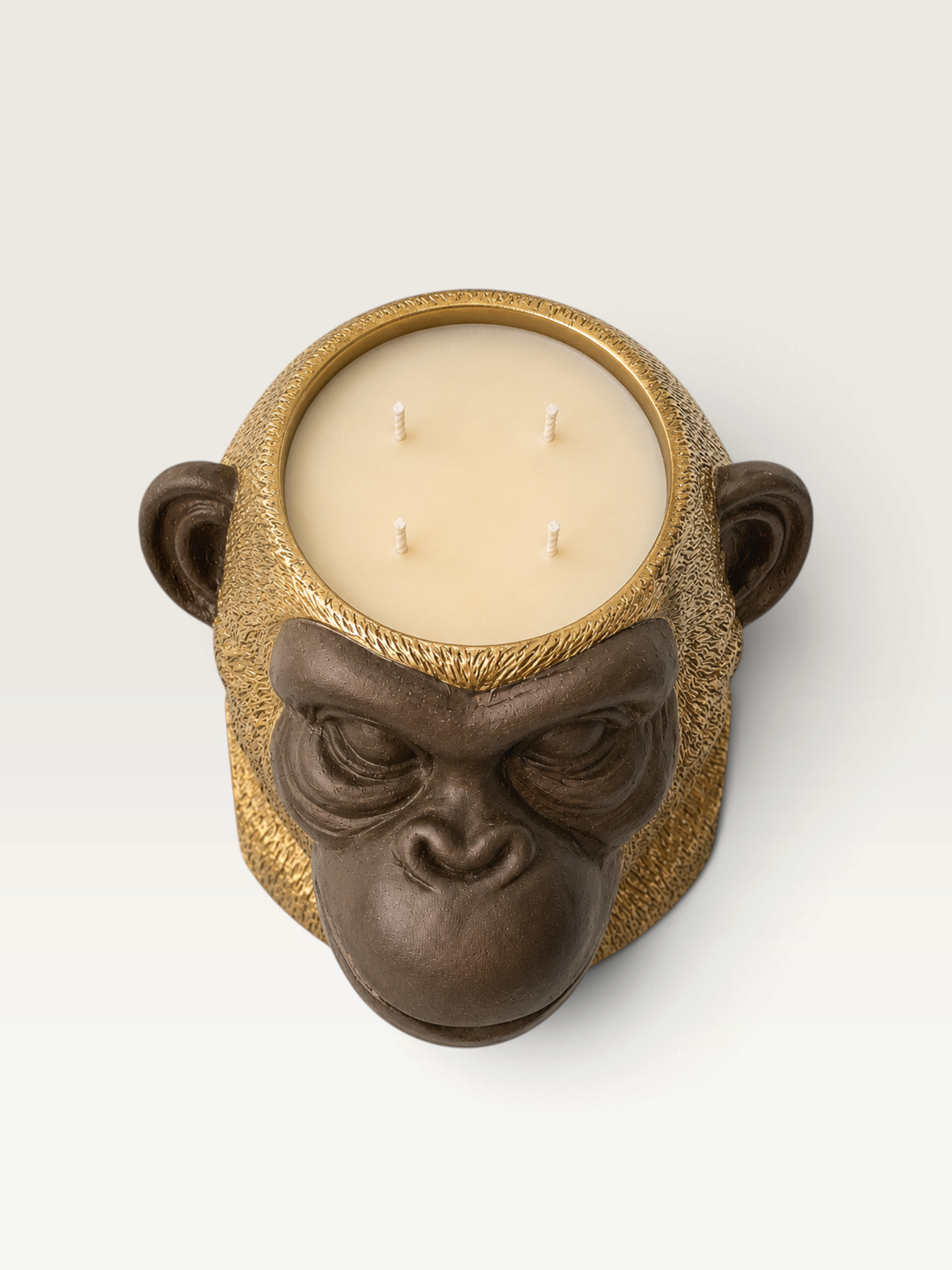 Vela decorativa THE IBIZA CANDLES con forma de cabeza de simio en tonos bronce y oro con cuatro mechas