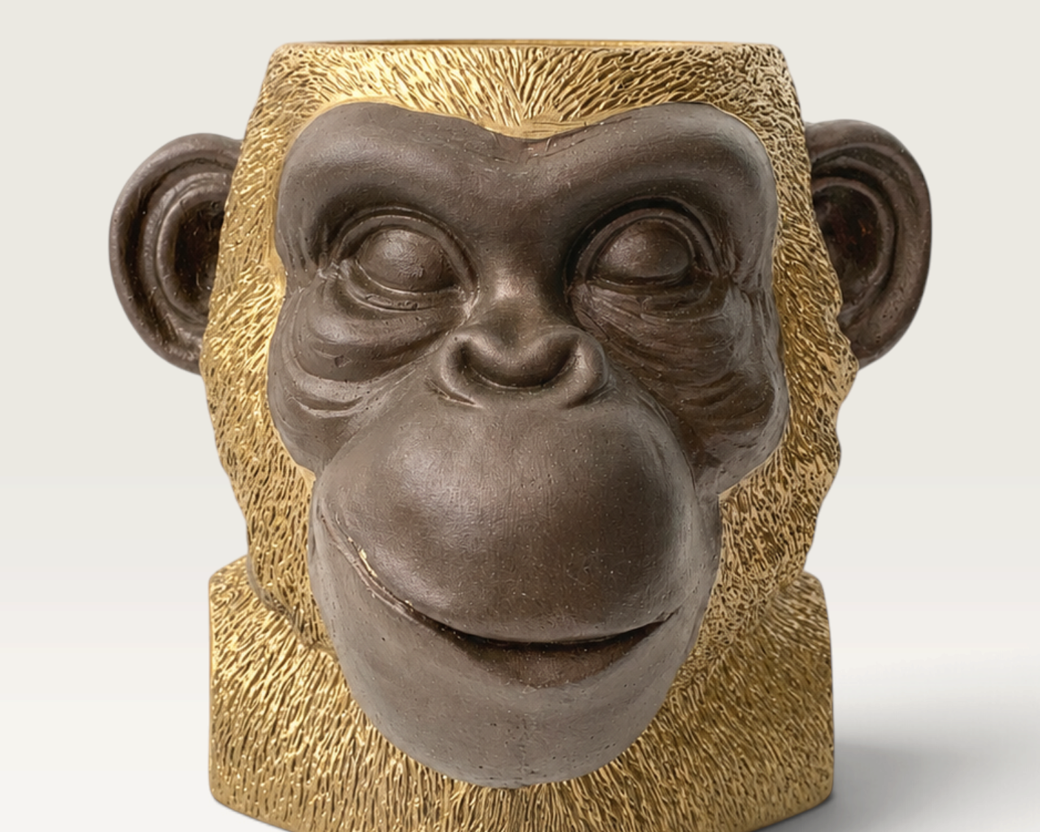 Vela decorativa THE IBIZA CANDLES con forma de cabeza de simio en tonos bronce y oro con diseño escultórico detallado