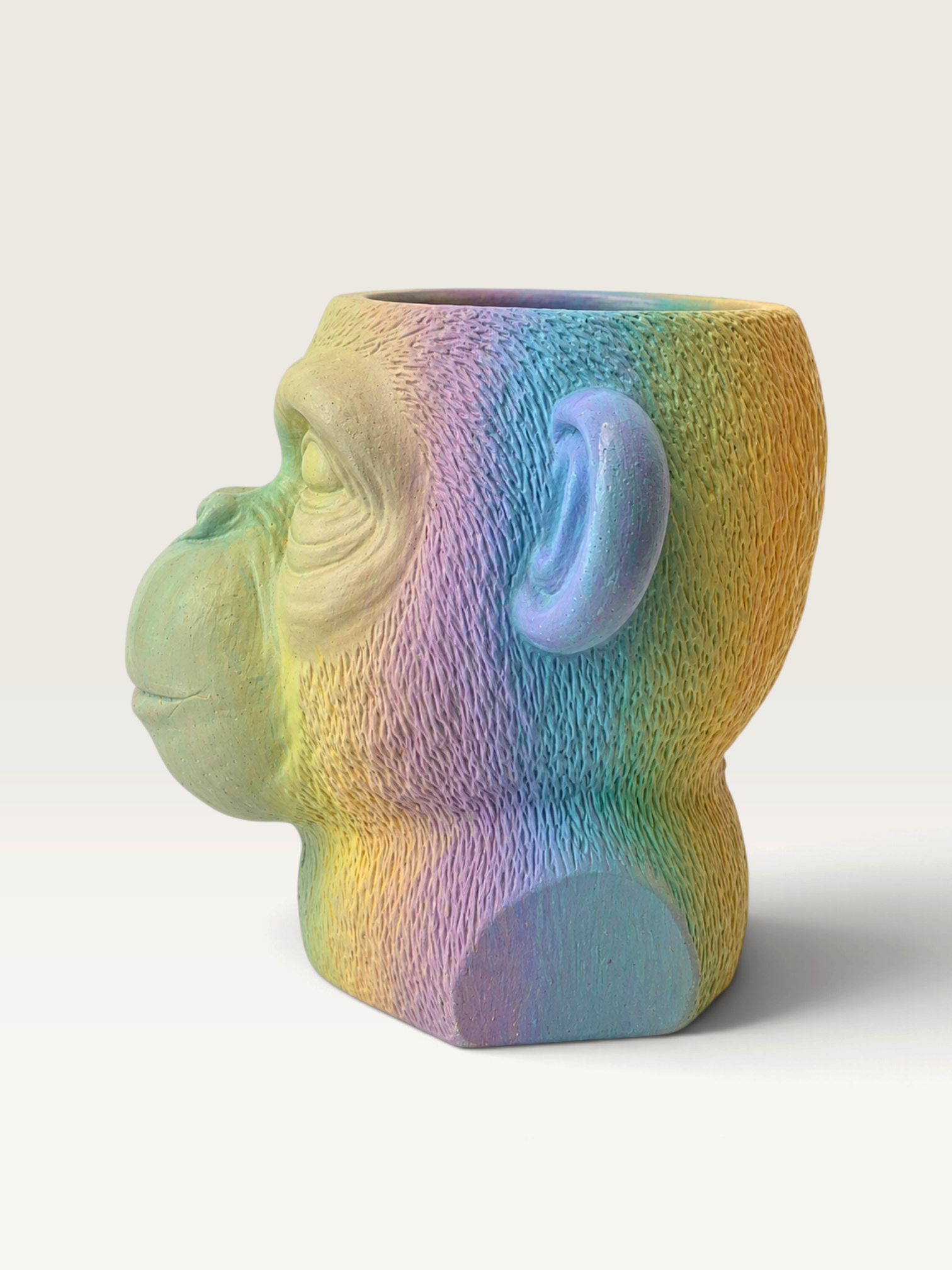 Vela escultórica Rainbow de THE IBIZA CANDLES con forma de cabeza de mono pintada a mano en tonos pastel degradados.