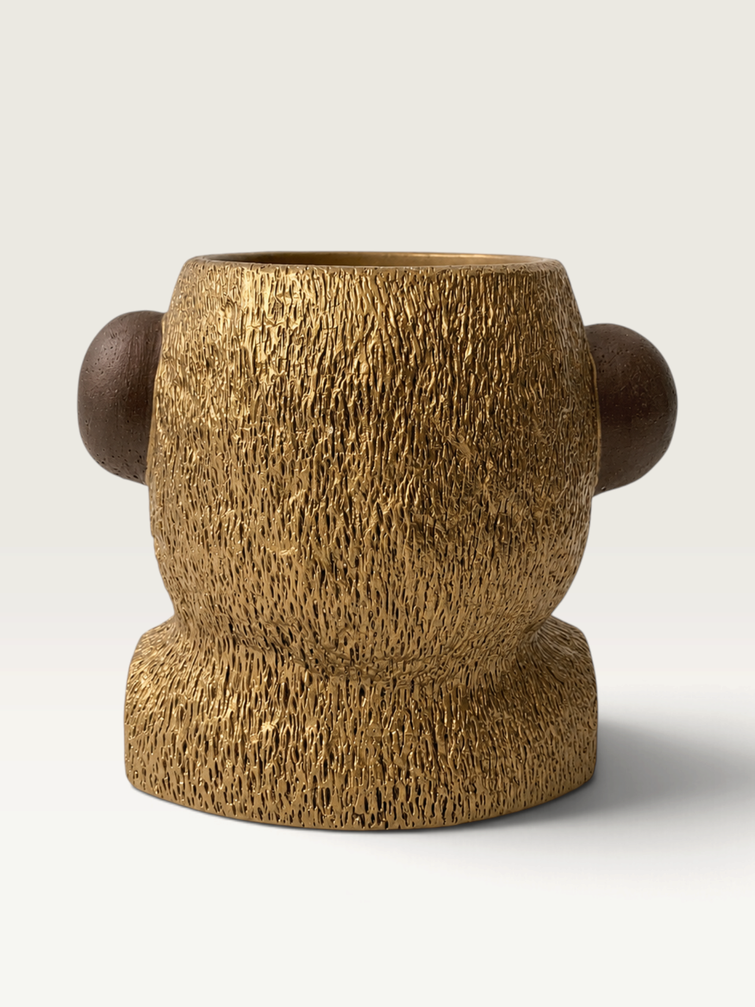 Vela decorativa THE IBIZA CANDLES con forma de cabeza de simio en tonos oro y bronce con textura detallada